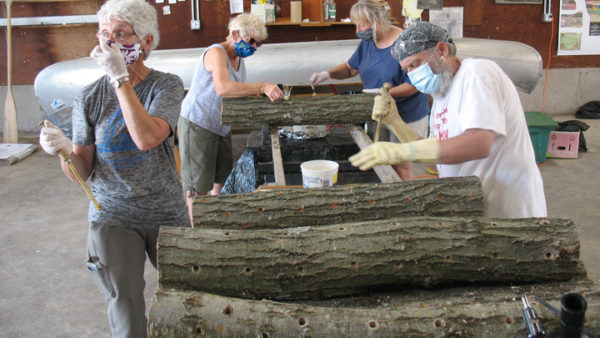 This is a picture of volunteers creating mushroom logs for Silverwood Park's mushroom workshop.