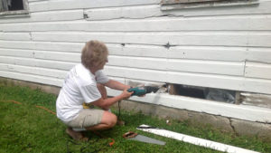 This is a picture of a Silverwood Park volunteer making repairs at the historic farmstead
