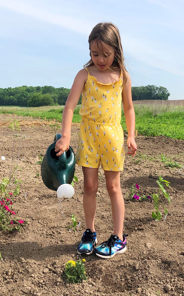 Education summer school girl in yellow watering