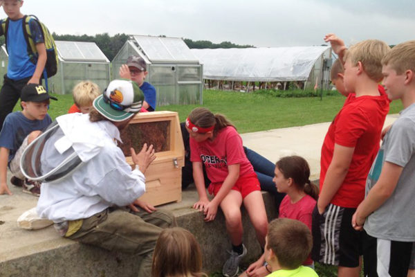 THis is a picture of Silverwood Summer School students with a beekeeper.